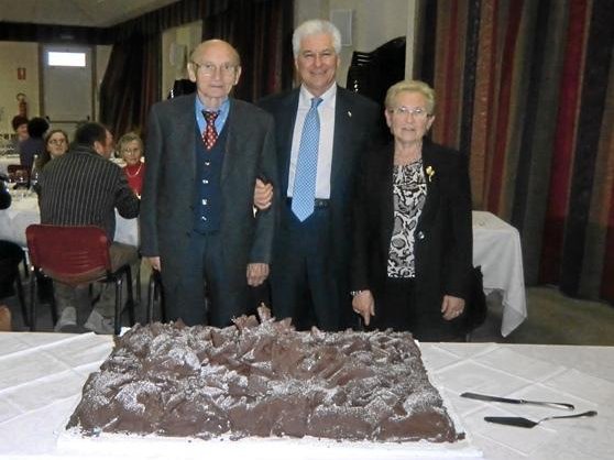 Drei Menschen stehen hinter einem Kuchen